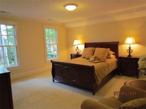 8 Rice Street, Unit 8 Wellesley, MA 02481 - Photo 5 of 10 a bed sitting in a bedroom next to a window