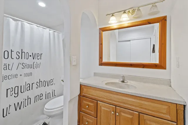 a bathroom with a sink a toilet and a mirror