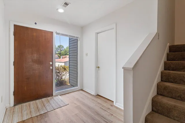 a view of a livingroom with wooden floor and stairs