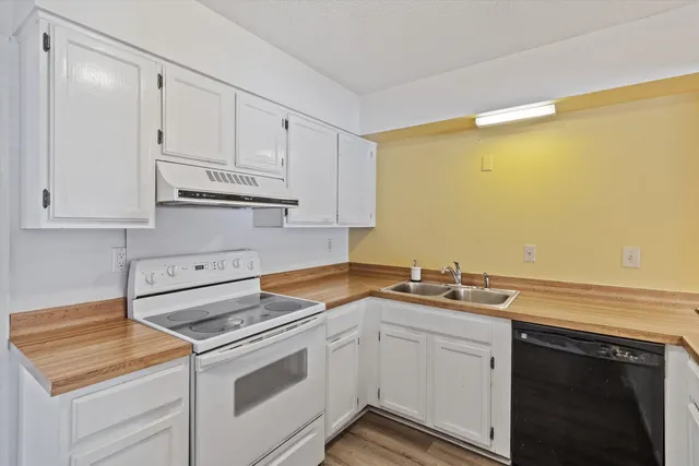 a kitchen with granite countertop white cabinets and white appliances