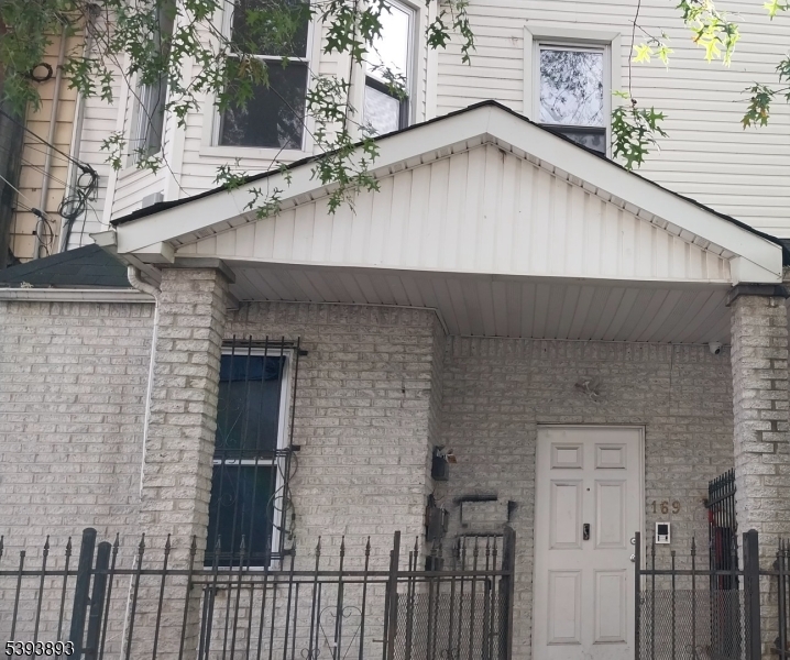 169 Mt Prospect Avenue Newark, NJ 07104 - Photo 1 of 16 a close view of a brick house with a small yard and large window