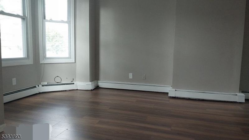 169 Mt Prospect Avenue Newark, NJ 07104 - Photo 16 of 16 an empty room with wooden floor and windows