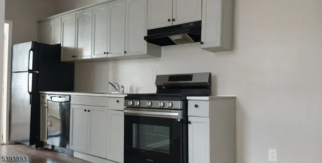 a kitchen with stainless steel appliances granite countertop white cabinets and black appliances