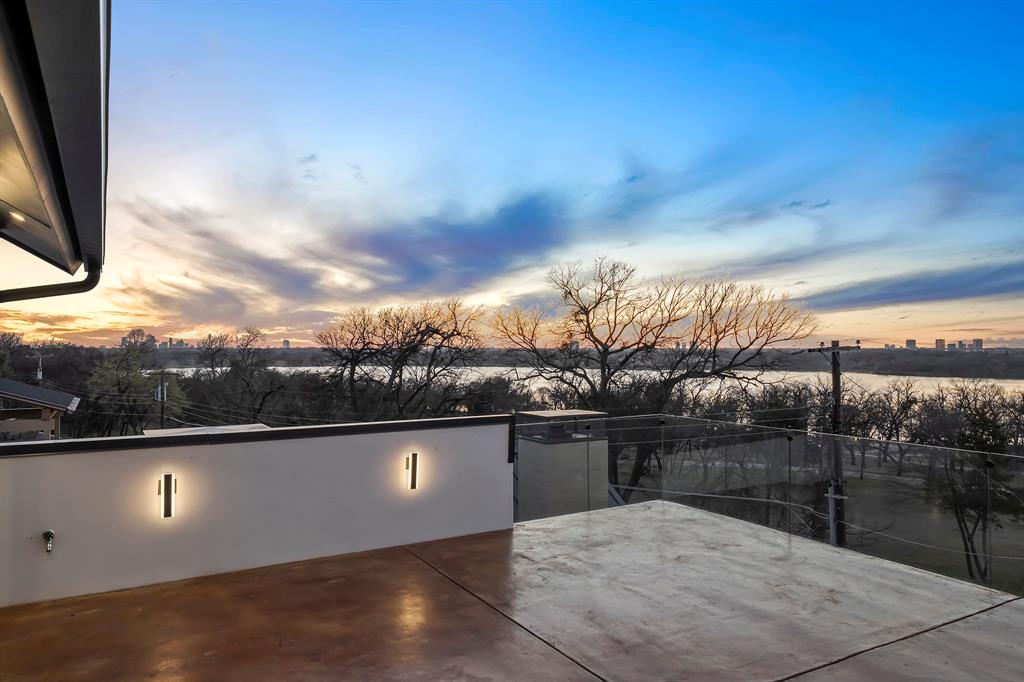 9457 Waterview Road Dallas, TX 75218 - Photo 2 of 25 Rooftop deck featuring a glass railing system, concrete flooring, and modern wall sconces