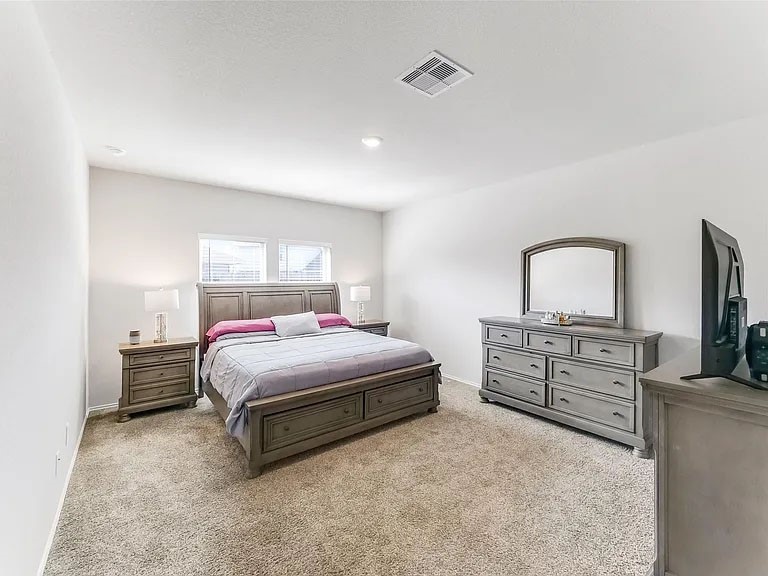 2406 High Spruce Circle Spring, TX 77373 - Photo 16 of 32 a bedroom with a bed and a flat screen tv