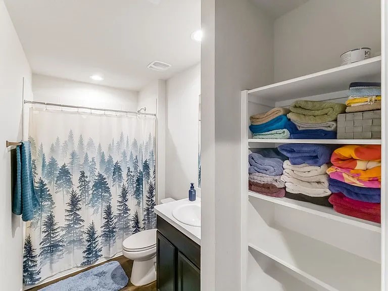 2406 High Spruce Circle Spring, TX 77373 - Photo 24 of 32 a bathroom with a toilet and a shower curtain