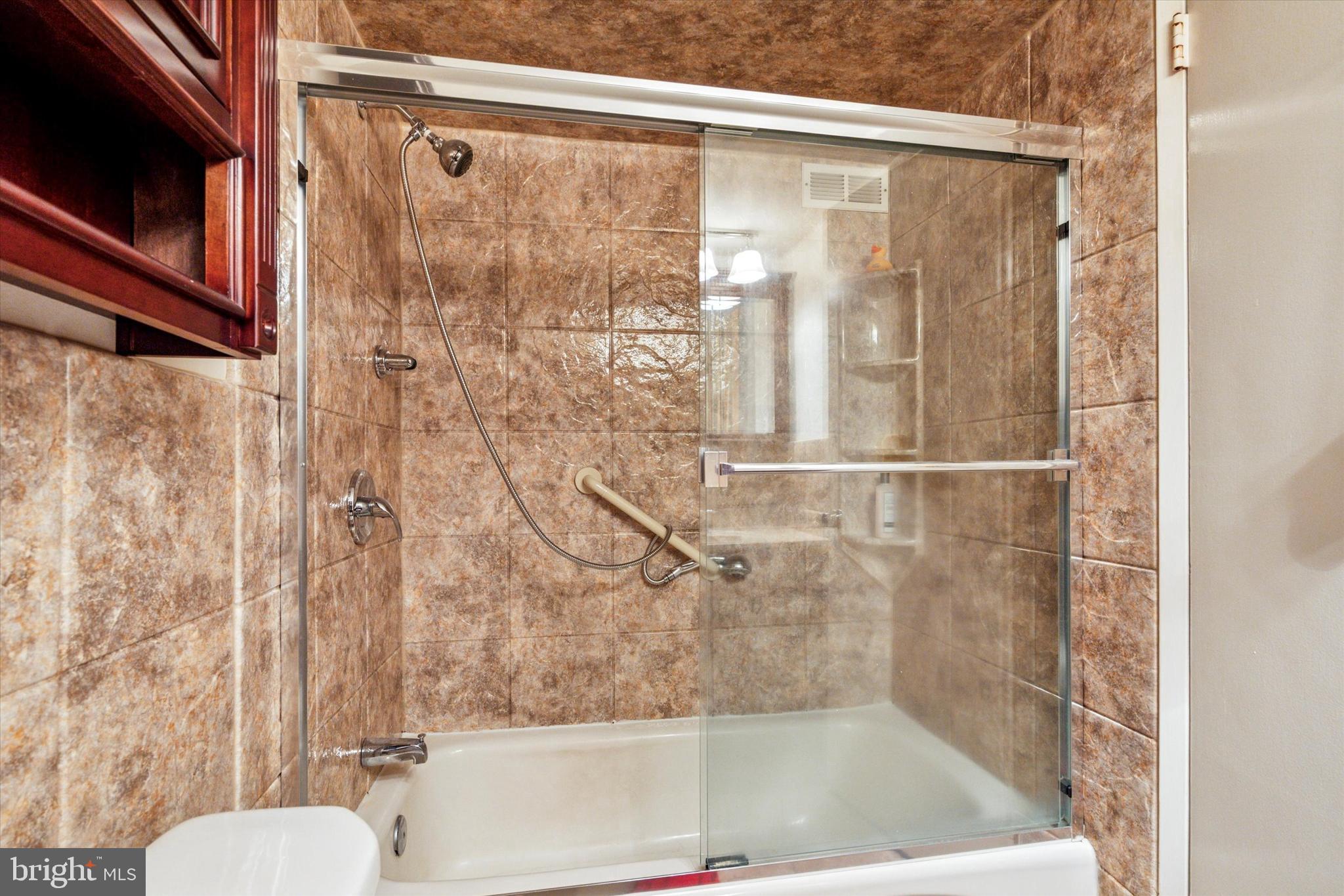 3900 West Ford Road, Unit 15C Philadelphia, PA 19131 - Photo 9 of 15 a bathroom with a bathtub and a shower