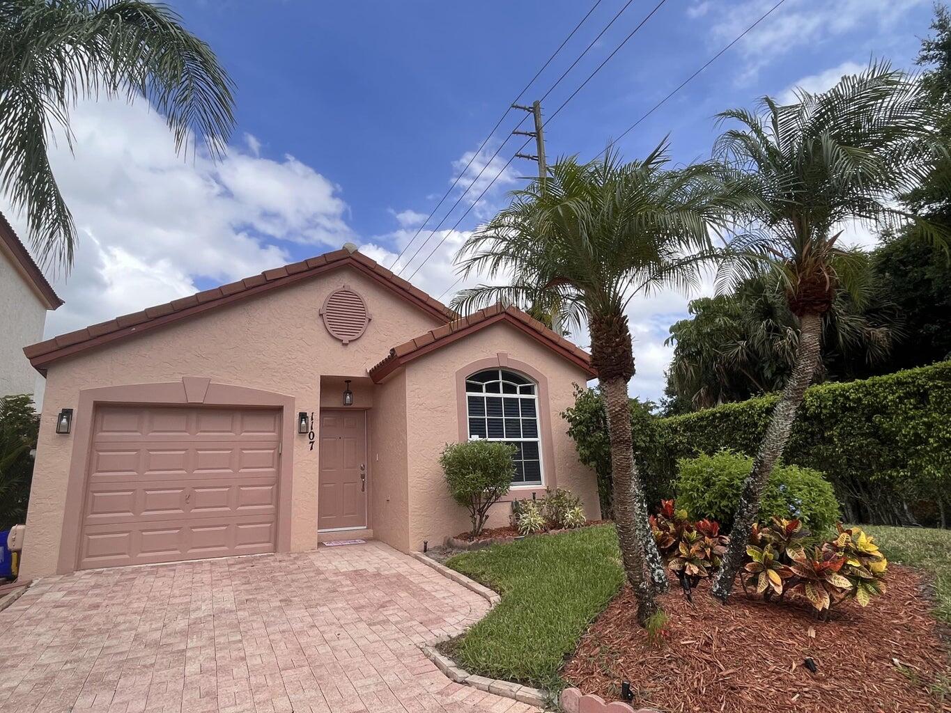 1107 Via Jardin Riviera Beach, FL 33418 - Photo 1 of 21 a front view of a house with a garden