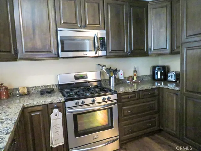 a kitchen with granite countertop white cabinets and stainless steel appliances