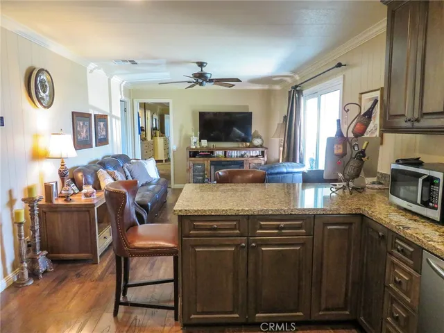 a kitchen with kitchen island granite countertop a stove and a flat screen tv