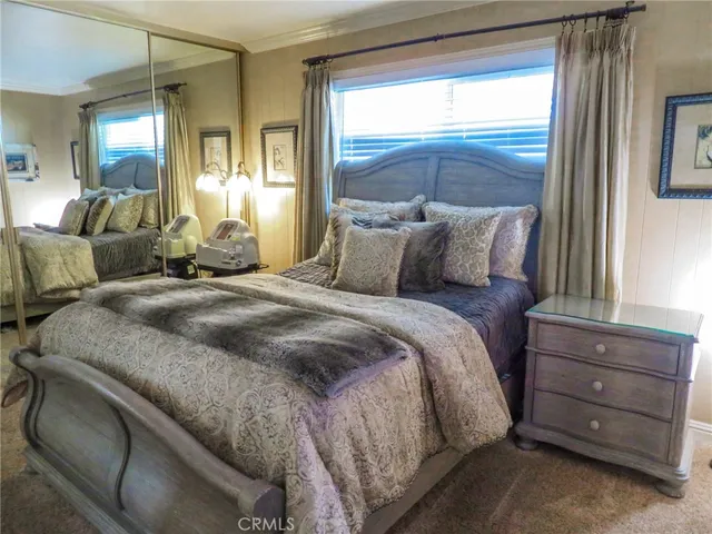 a large bed sitting in a bedroom next to a window