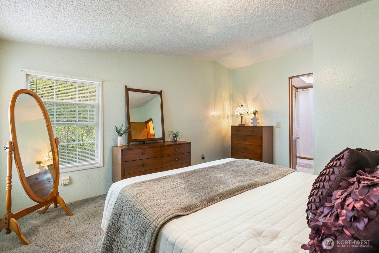 3191 Creasey Road Custer, WA 98240 - Photo 14 of 36 a bedroom with a bed a table in it and a mirror