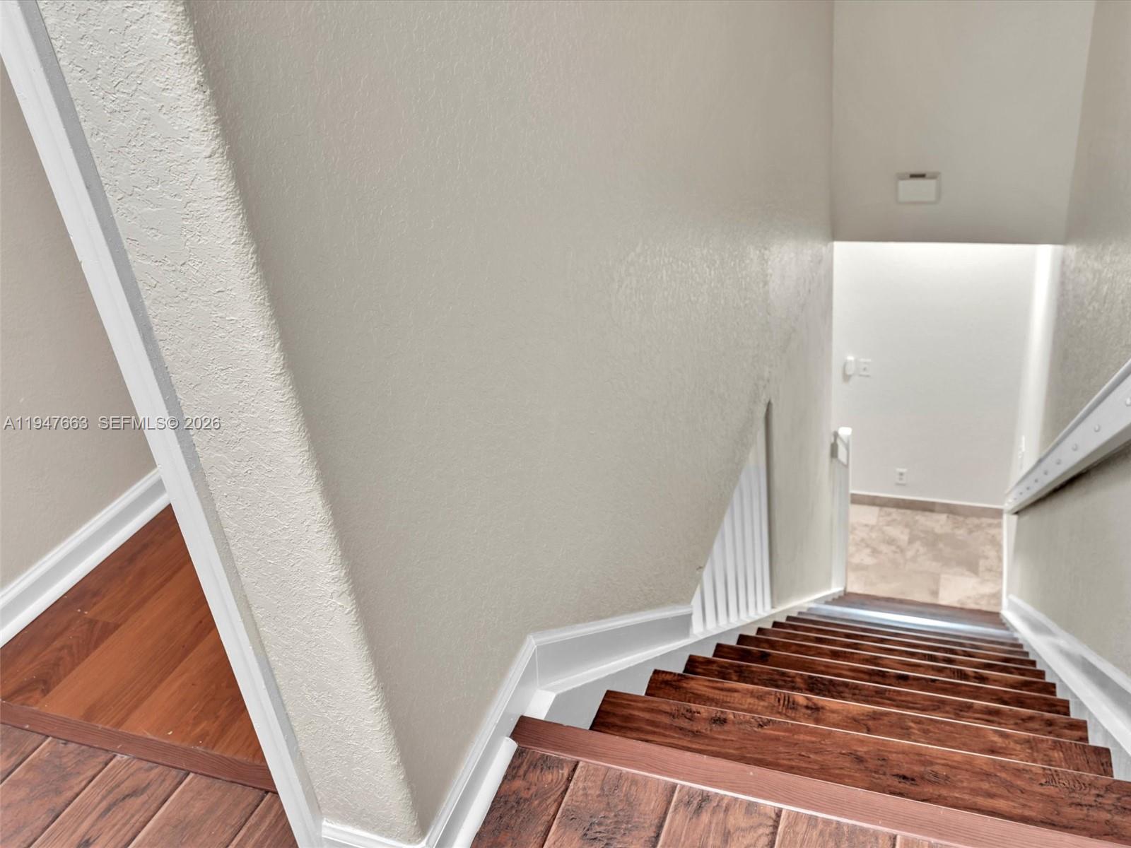 3853 Tree Top Drive, Unit 3853 Weston, FL 33332 - Photo 23 of 43 a view of a hallway to a house with wooden floor and stairs