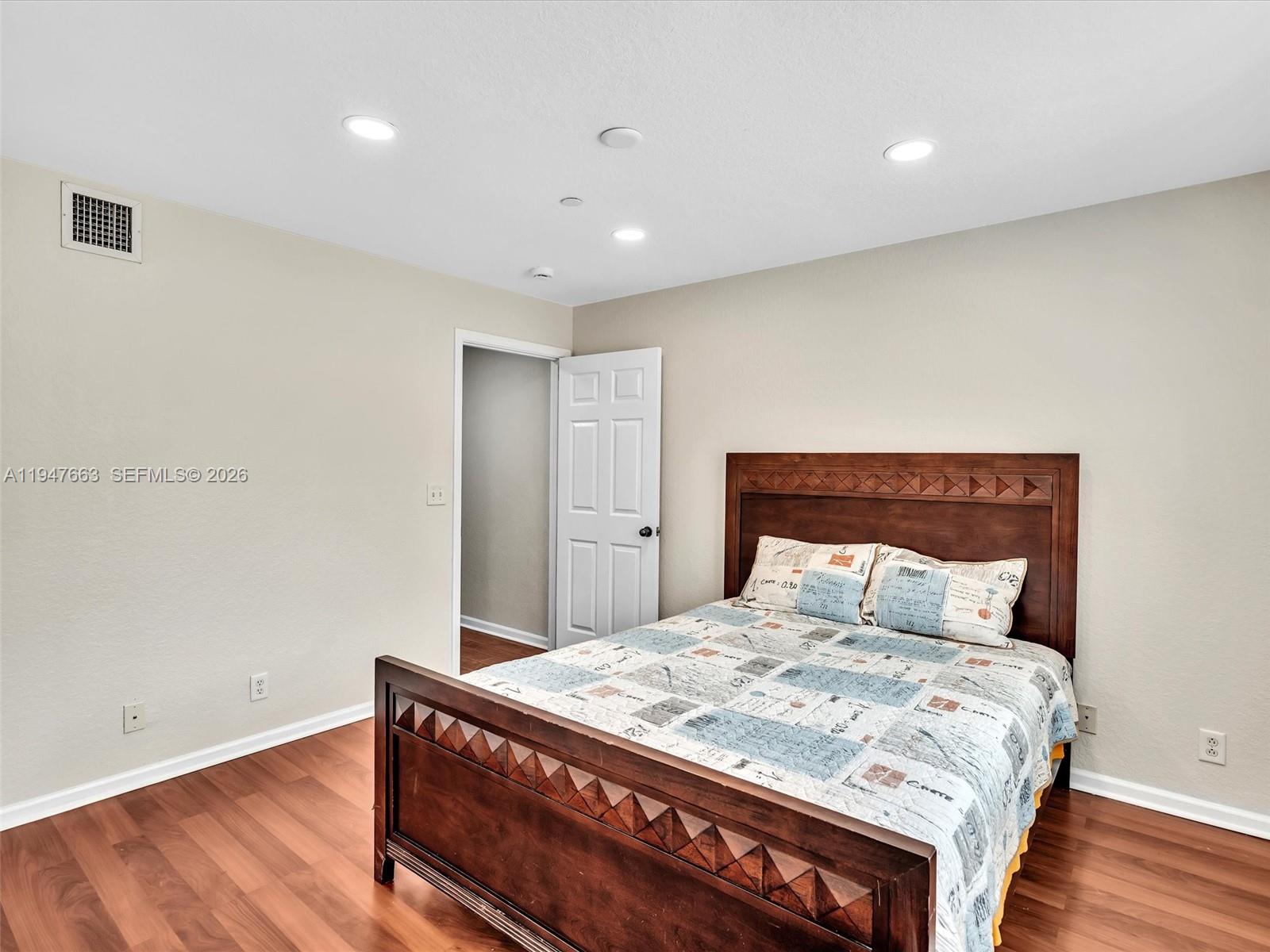 3853 Tree Top Drive, Unit 3853 Weston, FL 33332 - Photo 31 of 43 a bedroom with a bed and wooden floor