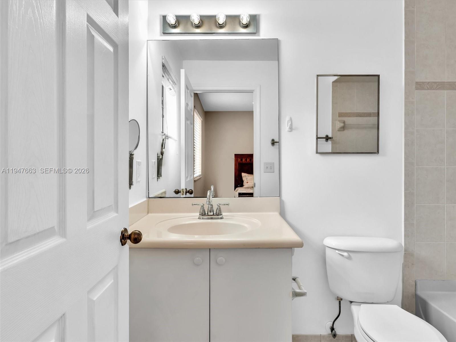 3853 Tree Top Drive, Unit 3853 Weston, FL 33332 - Photo 32 of 43 a bathroom with a sink mirror and toilet