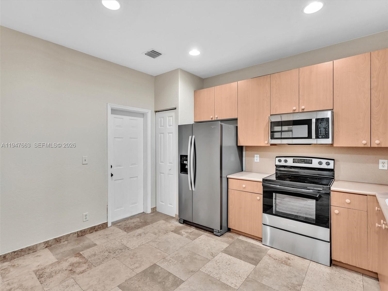 3853 Tree Top Drive, Unit 3853 Weston, FL 33332 - Photo 6 of 43 a kitchen with stainless steel appliances granite countertop a refrigerator stove and microwave