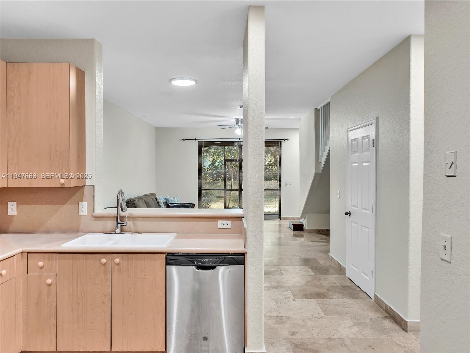 3853 Tree Top Drive, Unit 3853 Weston, FL 33332 - Photo 9 of 43 a kitchen with granite countertop a sink and white cabinets