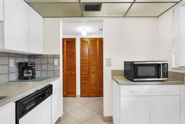 a kitchen with a sink white cabinets and white appliances