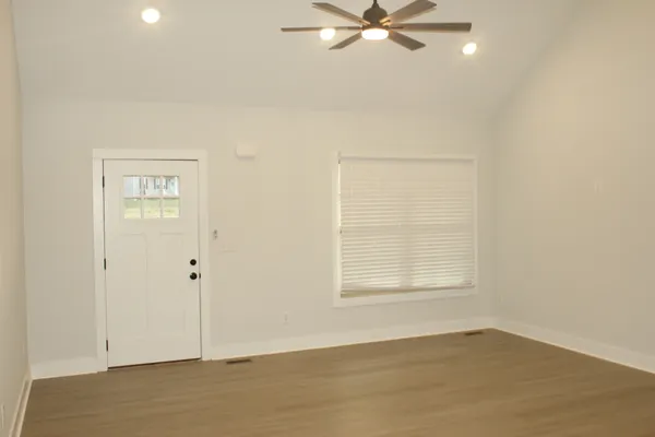 an empty room with fan and windows