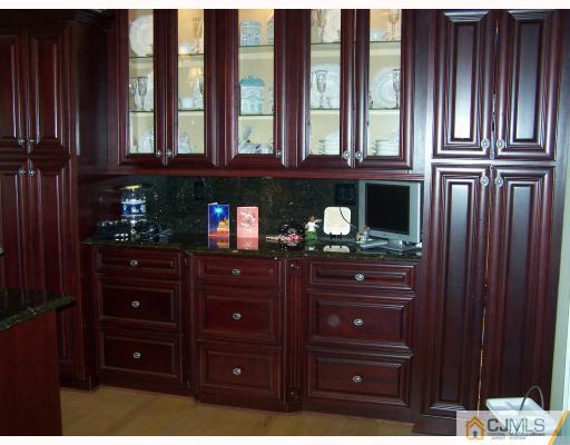 115 Westley Road Old Bridge, NJ 08857 - Photo 4 of 10 a kitchen with a wooden floor and cabinets