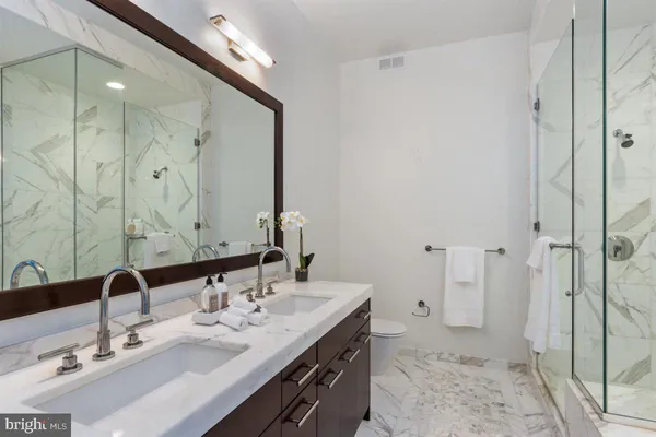 a bathroom with a double vanity sink mirror and shower