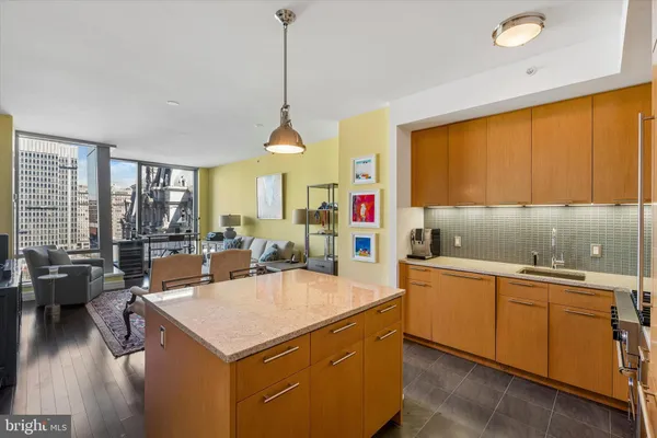 a kitchen with a stove a sink a counter space and living room view