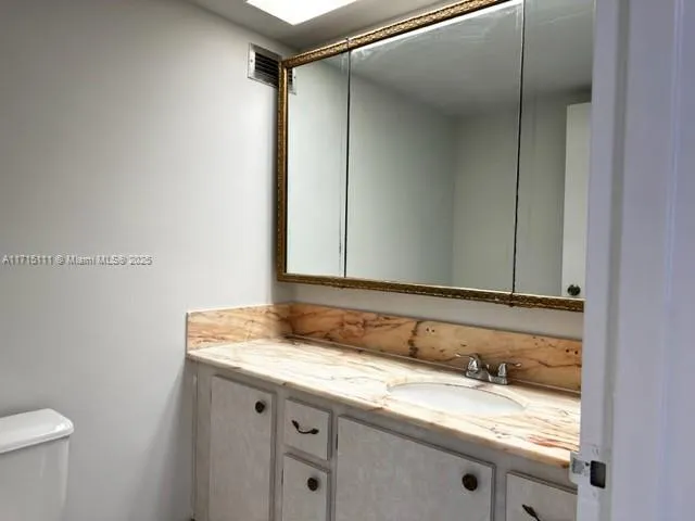 a bathroom with a granite countertop sink and a mirror