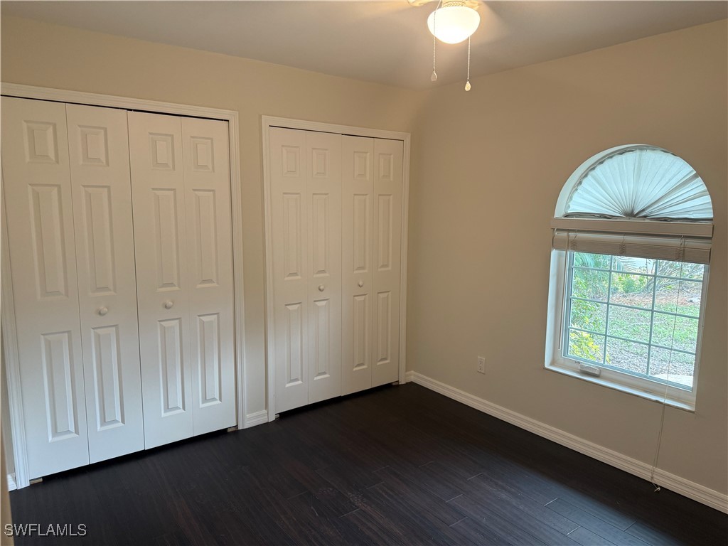 18249 Oak Road Fort Myers, FL 33967 - Photo 12 of 16 an empty room with wooden floor cabinet and windows