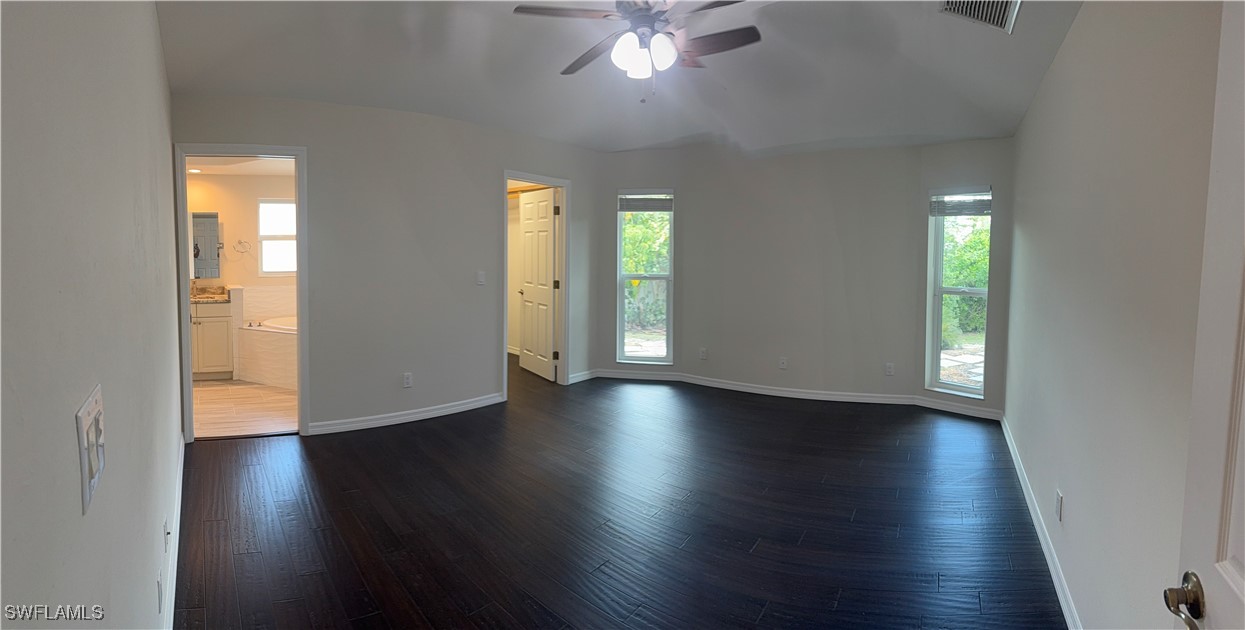 18249 Oak Road Fort Myers, FL 33967 - Photo 13 of 16 an empty room with wooden floor and windows