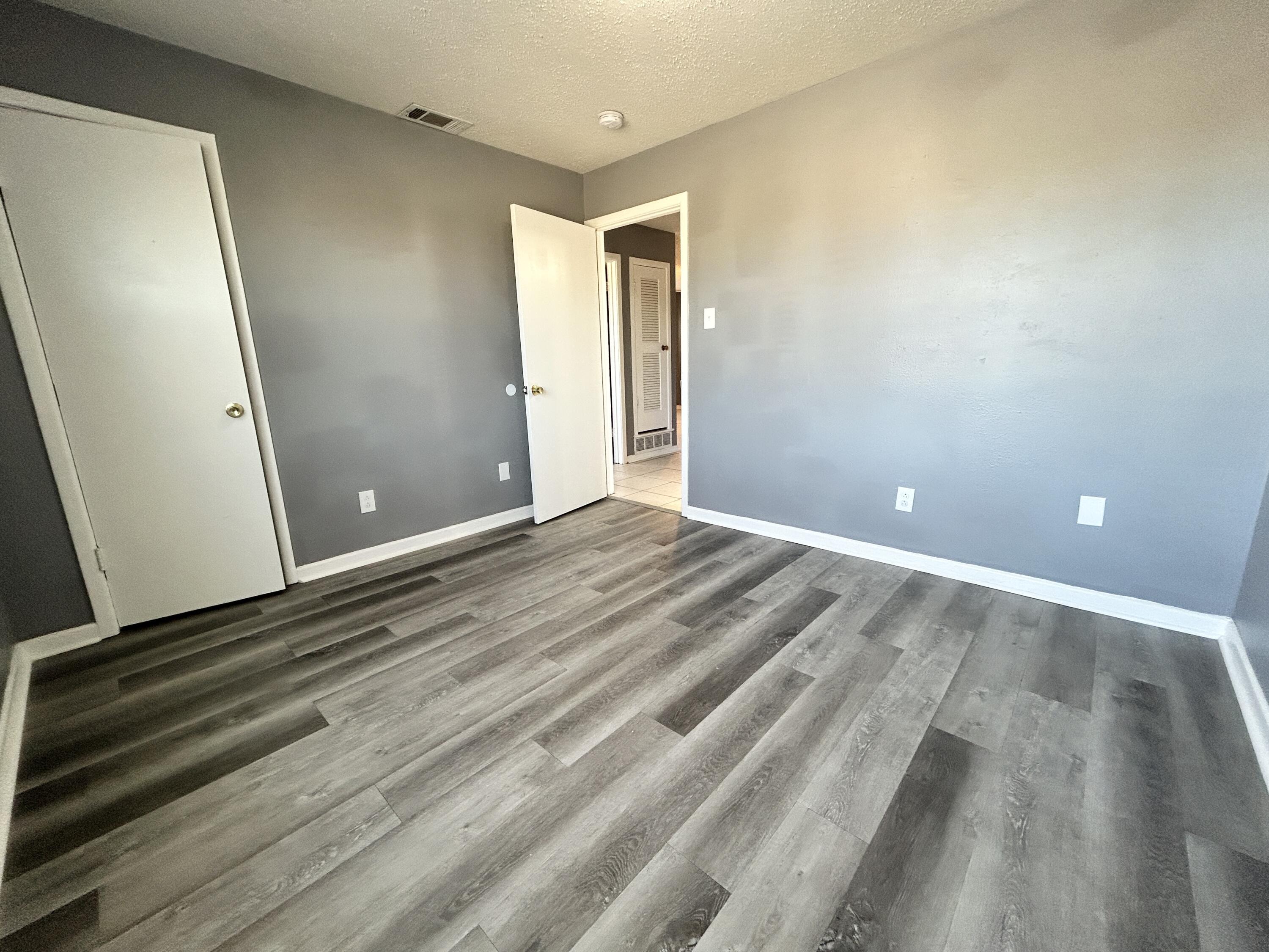 5533 34th Street, Unit A Lubbock, TX 79407 - Photo 8 of 12 a view of a room with wooden floor and bathroom
