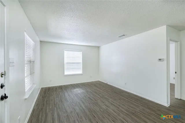 a view of a room with wooden floor and window
