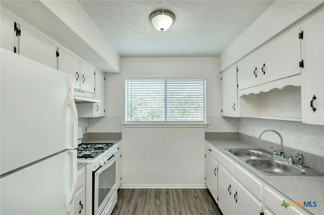 a kitchen with stainless steel appliances a sink a stove and a refrigerator