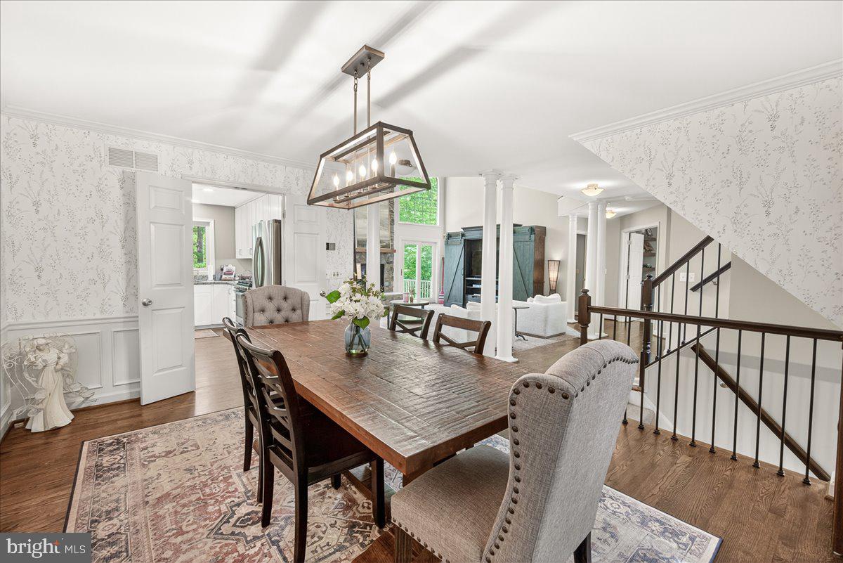 10490 Lakeridge Court New Market, MD 21774 - Photo 11 of 79 a view of a dining room and livingroom with furniture wooden floor a rug a painting and a chandelier
