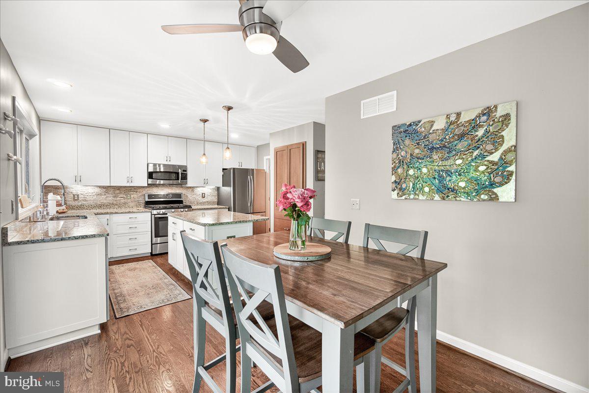 10490 Lakeridge Court New Market, MD 21774 - Photo 19 of 79 a kitchen with stainless steel appliances granite countertop a dining table chairs refrigerator and microwave