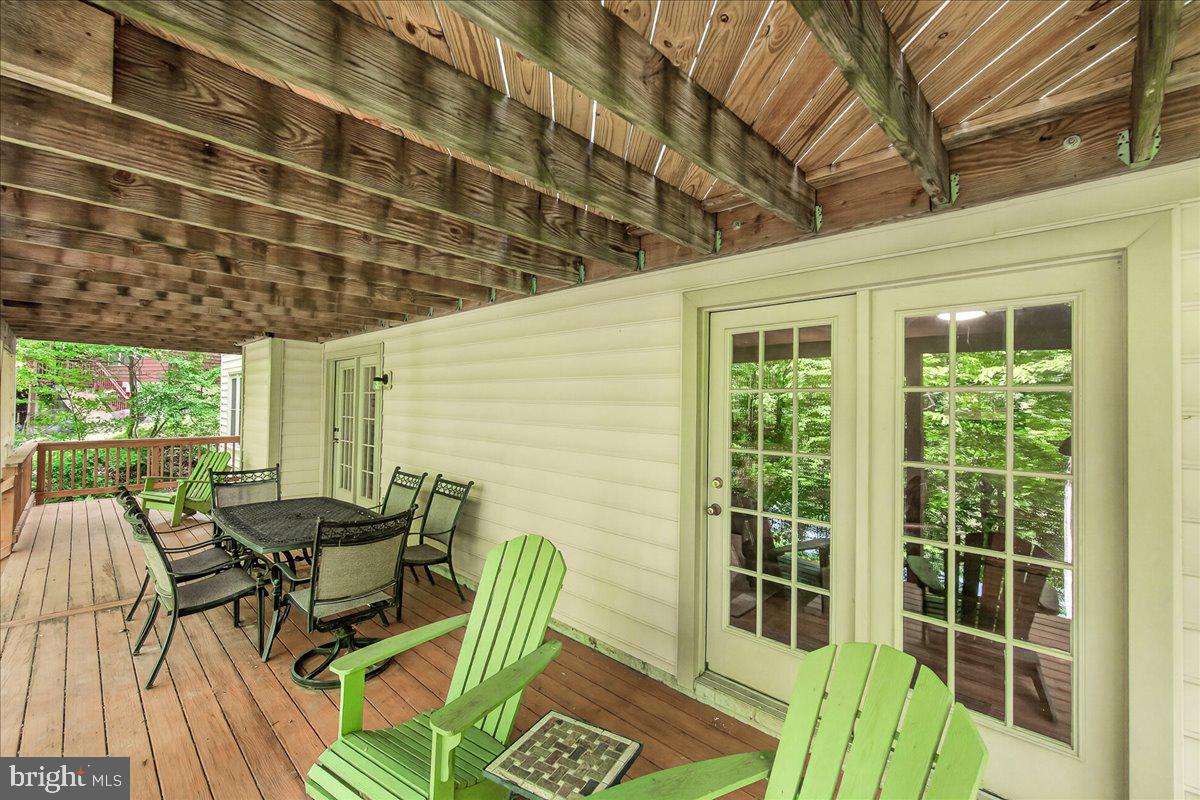 10490 Lakeridge Court New Market, MD 21774 - Photo 46 of 79 a view of a patio with table and chairs with wooden floor and fence