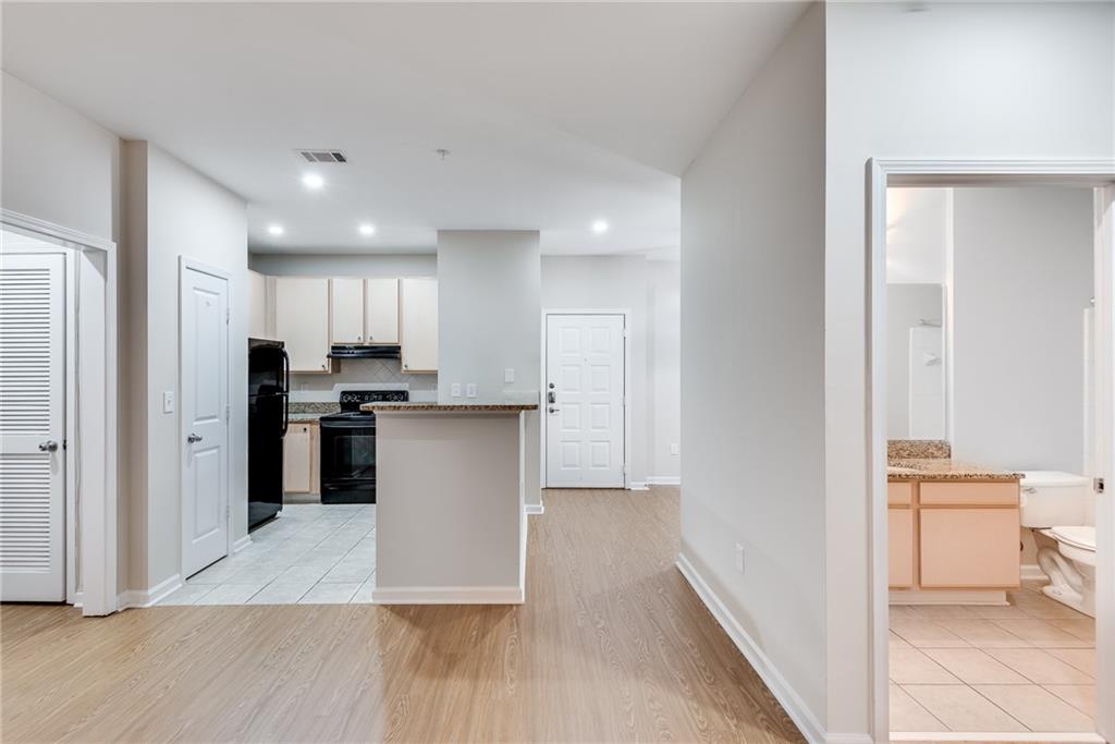 a kitchen with stainless steel appliances kitchen island granite countertop a refrigerator and a sink
