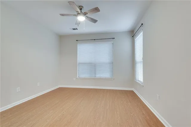 an empty room with a window and a fan