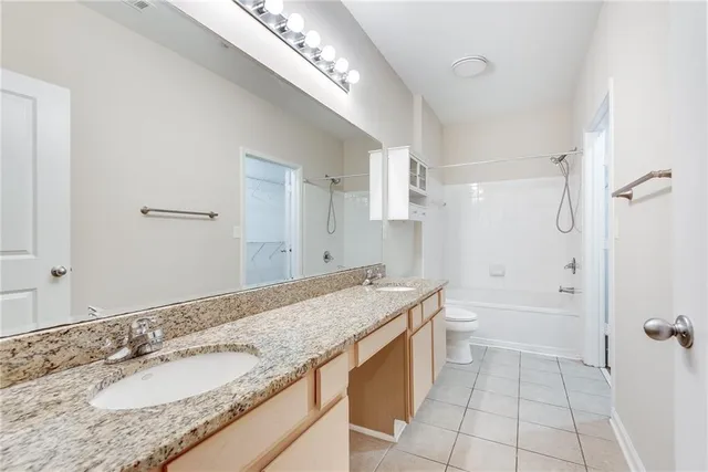 a bath room with a granite countertop sink and a mirror