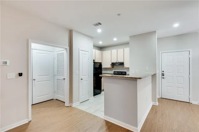 a open kitchen with white cabinets and refrigerator