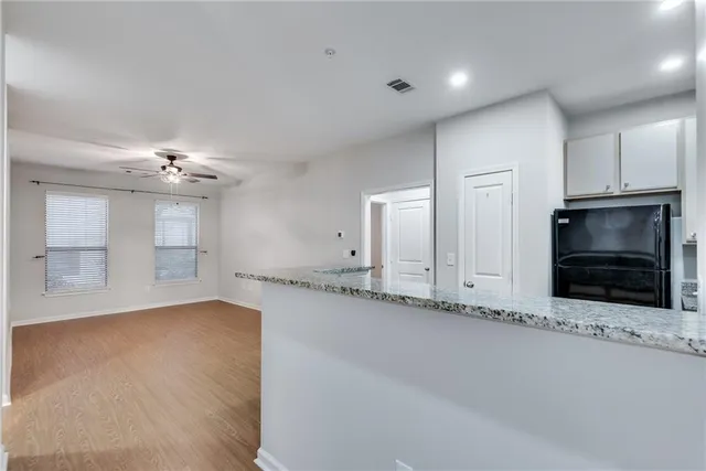 an empty room with a fireplace and chandelier fan