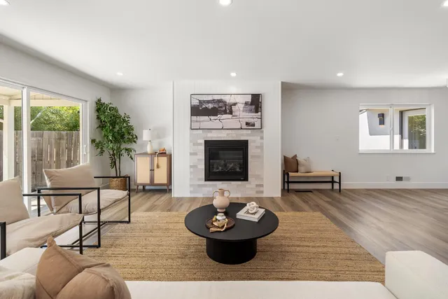 a kitchen with stainless steel appliances granite countertop a table chairs stove and wooden floor