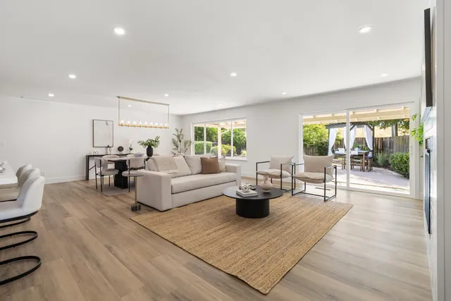 a kitchen with stainless steel appliances a sink wooden floor cabinets and a window