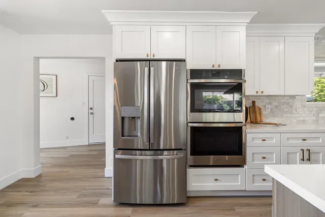 a bedroom with bed and a painting on the wall