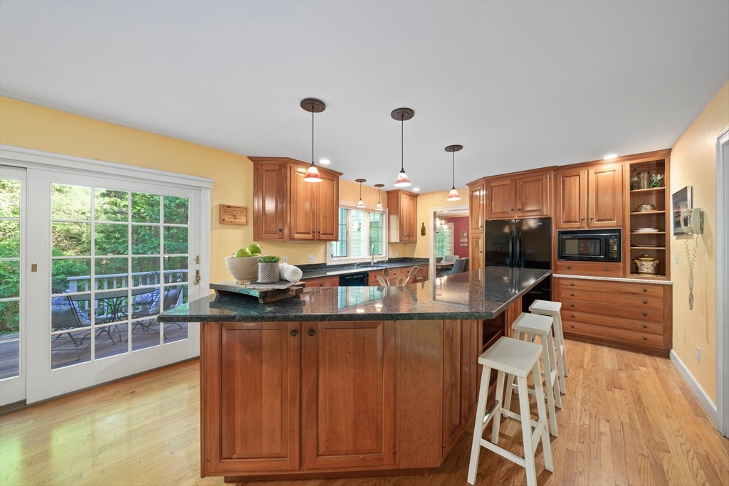 155 Pine Street Medfield, MA 02052 - Photo 6 of 40 a kitchen with kitchen island granite countertop a sink and wooden cabinets