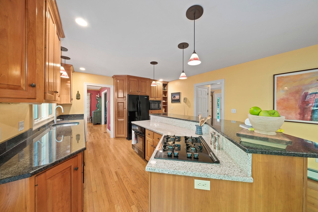 155 Pine Street Medfield, MA 02052 - Photo 7 of 40 a kitchen with stainless steel appliances granite countertop a stove a refrigerator a sink a dining table and chairs with wooden floor