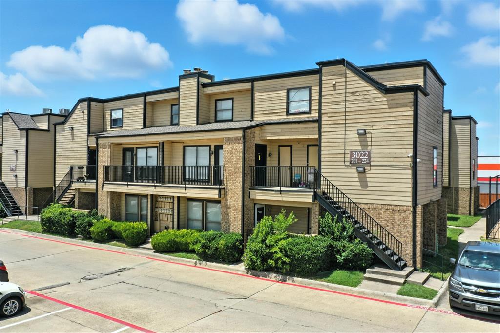 3022 Forest Lane, Unit 308 Dallas, TX 75234 - Photo 3 of 21 a front view of a house with a yard