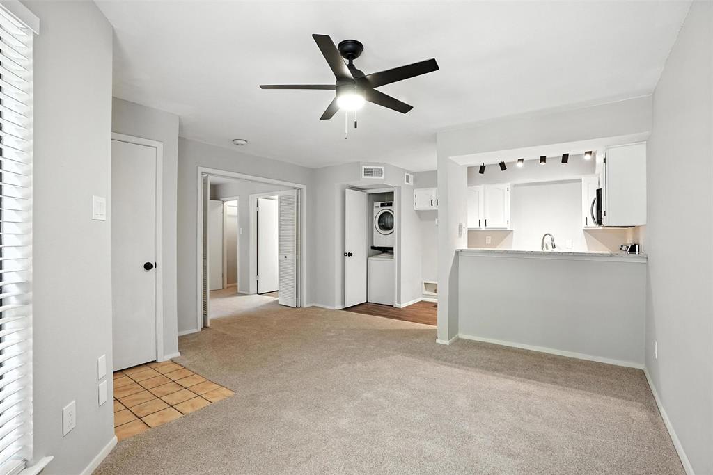 3022 Forest Lane, Unit 308 Dallas, TX 75234 - Photo 8 of 21 a living room with a ceiling fan and a rug