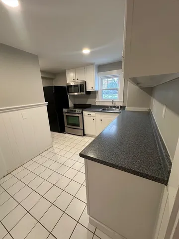 a kitchen with kitchen island sink and refrigerator