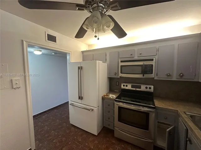 a kitchen with stainless steel appliances a refrigerator and a stove top oven