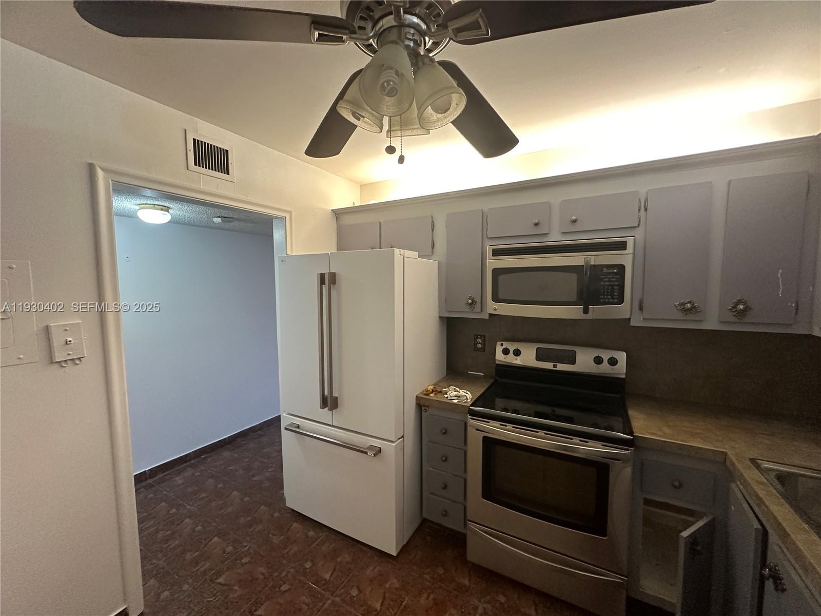 4740 Northwest 21st Street, Unit 214 Lauderhill, FL 33313 - Photo 13 of 15 a kitchen with stainless steel appliances a refrigerator and a stove top oven
